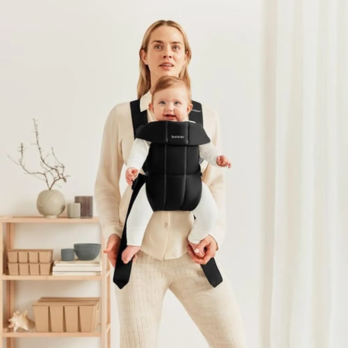 Parent wearing the BabyBjörn Mini with the baby facing outwards