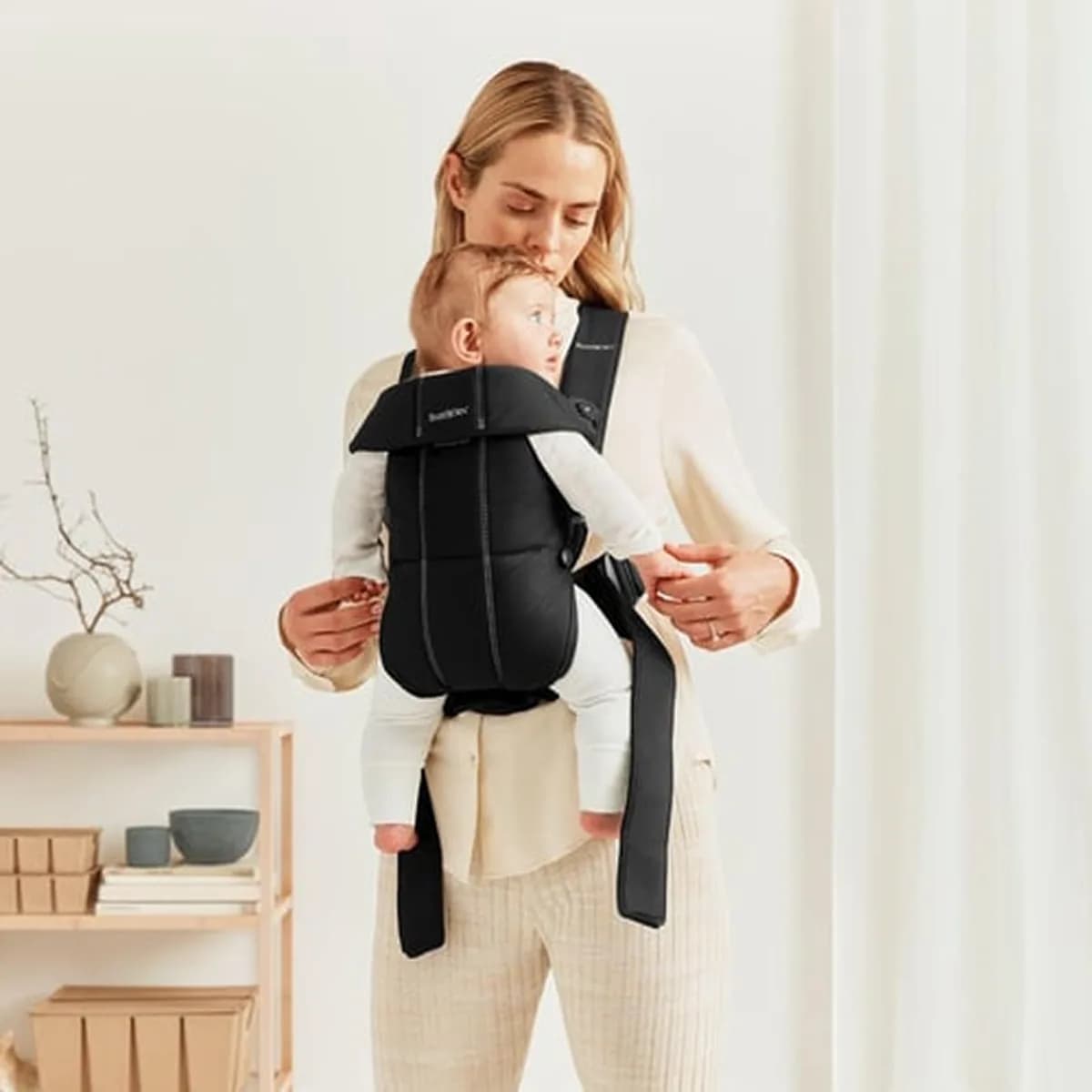 Parent adjusting the BabyBjörn Mini with the baby facing inwards